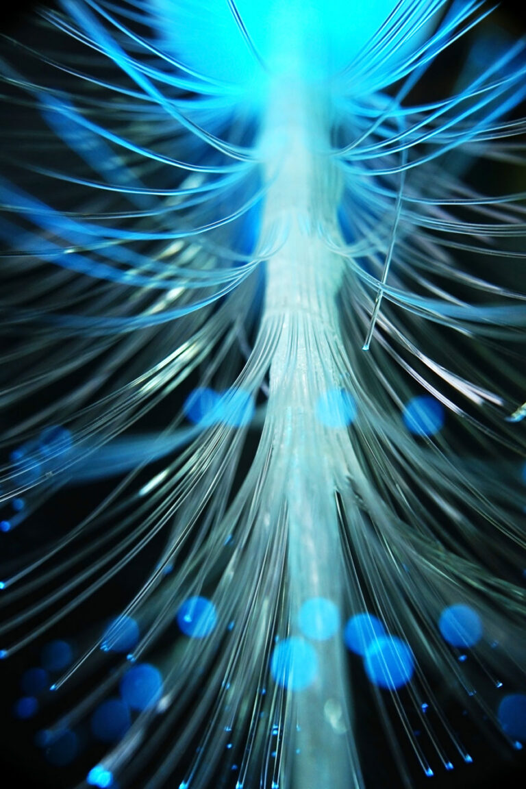 brightly lit blue fiberoptic strands in dark room