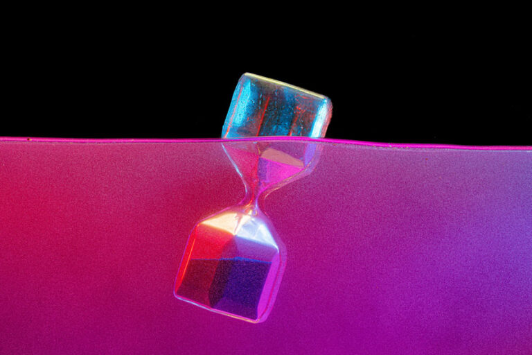 hourglass submerged in liquid with abstract background
